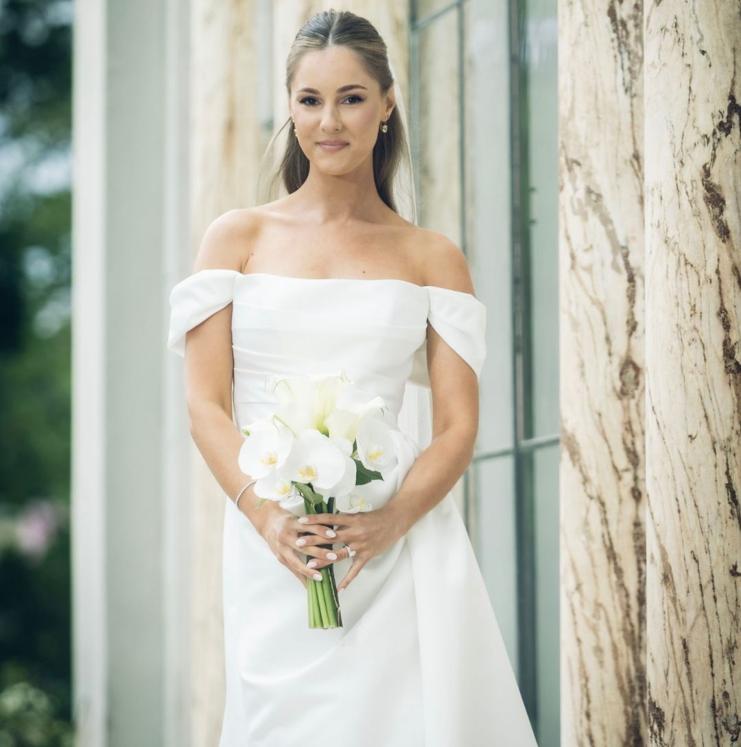 Vacker brud i brudklänning och med brudbukett