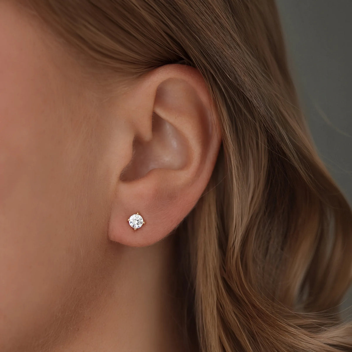 Närbild av ett öra med North Stud från Schalins i rödguld med en rund diamant på 0,30 ct.