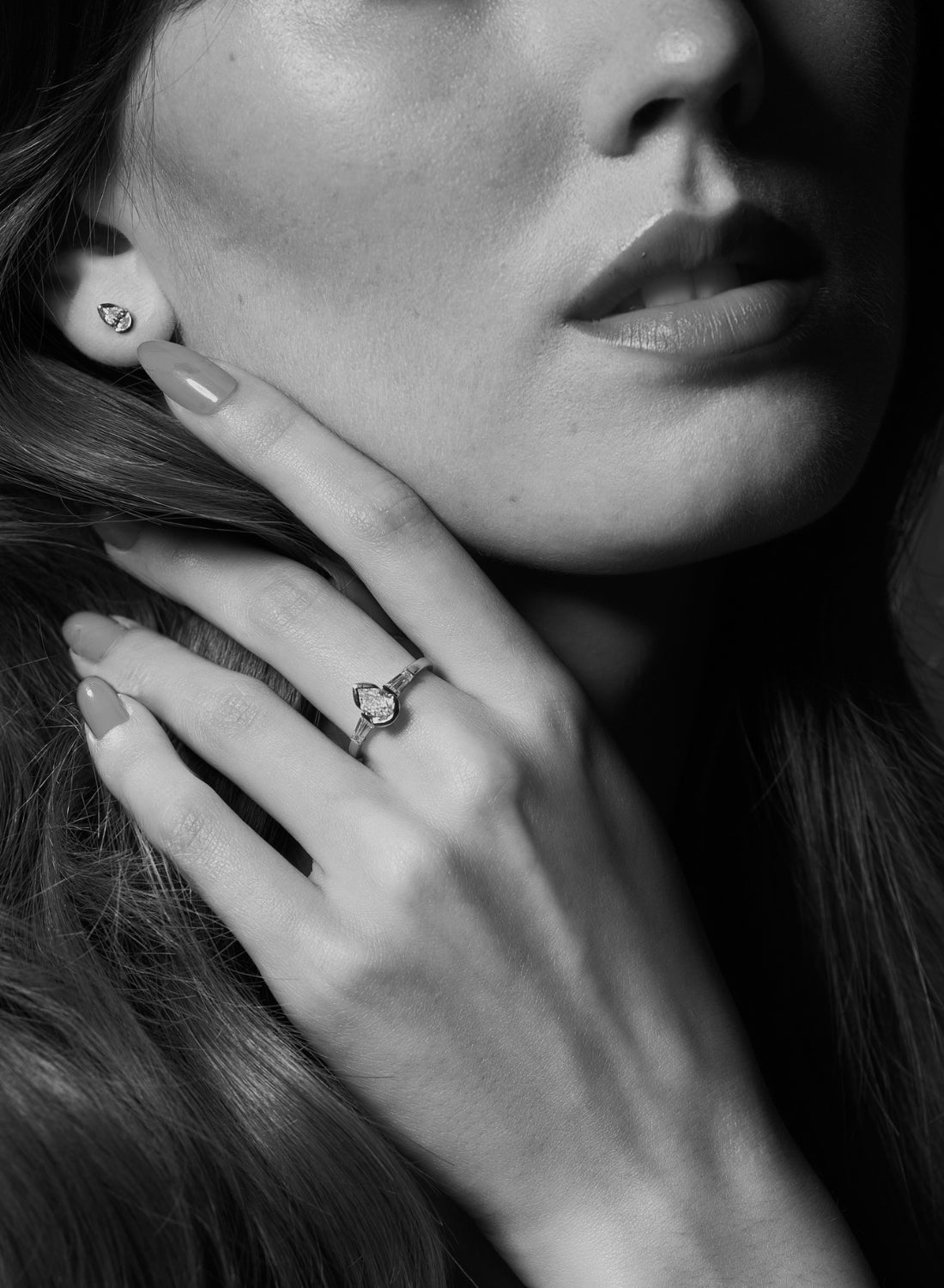 Närbild på Eloge ring med droppformad diamant (pear cut) på hand, elegant design från Schalins