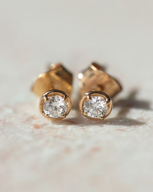 Närbild på guldörhänge med diamant