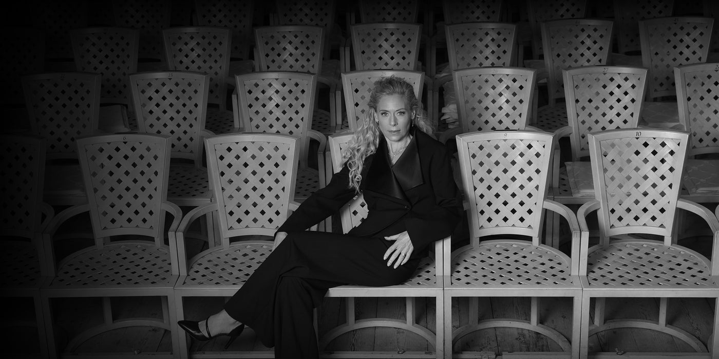 Bild på Eva Röse sittandes på en stol i en teatersalong. 