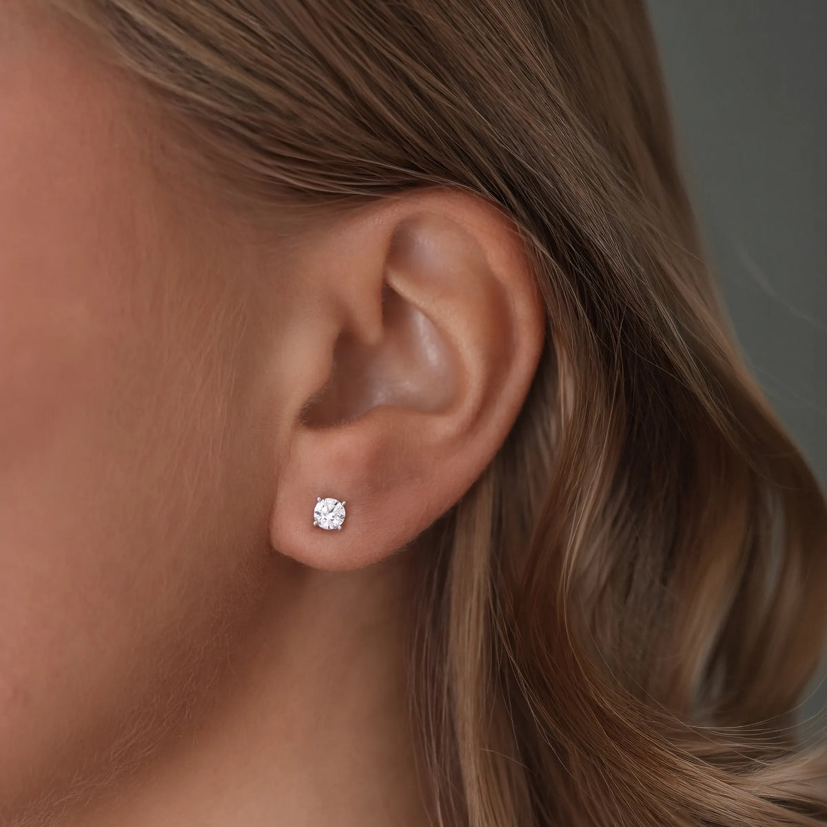 Närbild av ett öra med North Stud från Schalins i vitguld med en rund diamant på 0,30 ct.