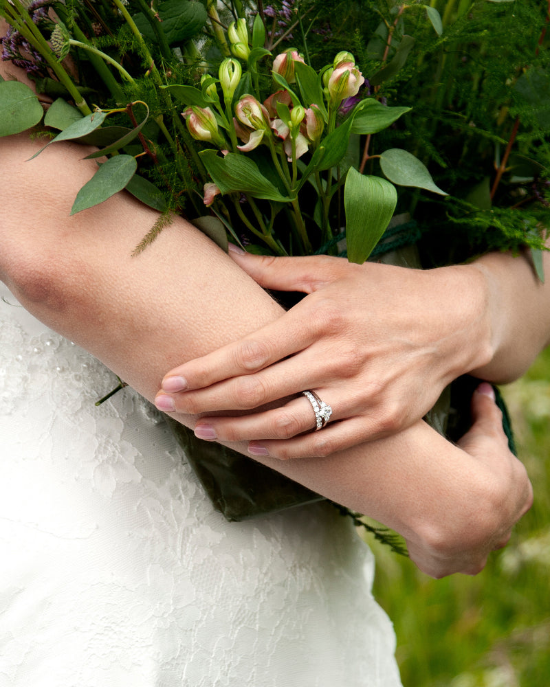 Brud med Eterna trestensring och helalliansring på handen, bröllopsringar från Schalins med fokus på elegans och detaljer
