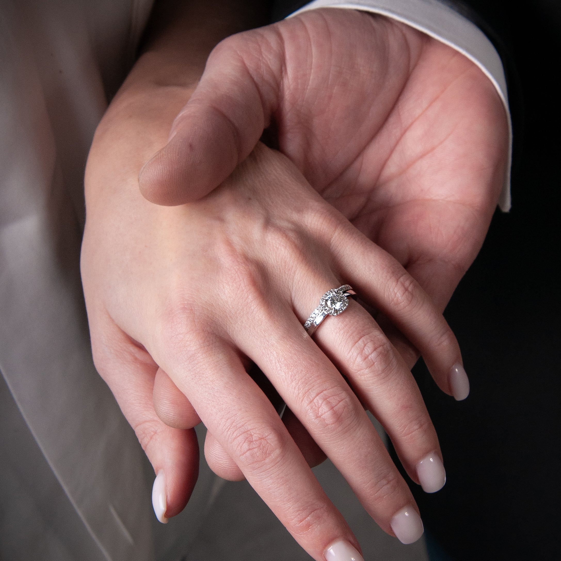Hand med ringkombination av solitärring Love 05 och alliansring Love 07 i vitt guld