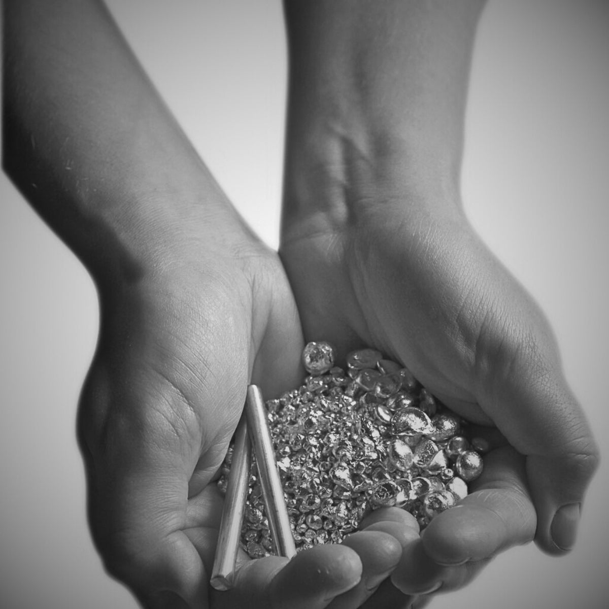 Händer som håller lösa diamanter som symboliserar Schalins svenska hantverk och materialval i guld och legeringar