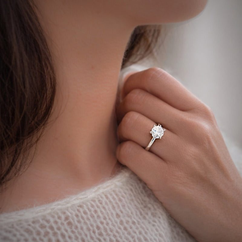 Kvinna bär solitärring med lab grown diamant i vitguld från Schalins North-kollektion, hand vid hals